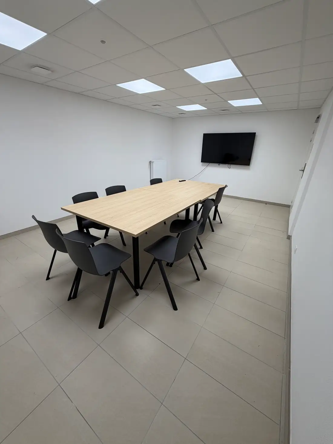 Salle de réunion de la résidence Impul'S à Rennes avec grande table, chaises et écran mural